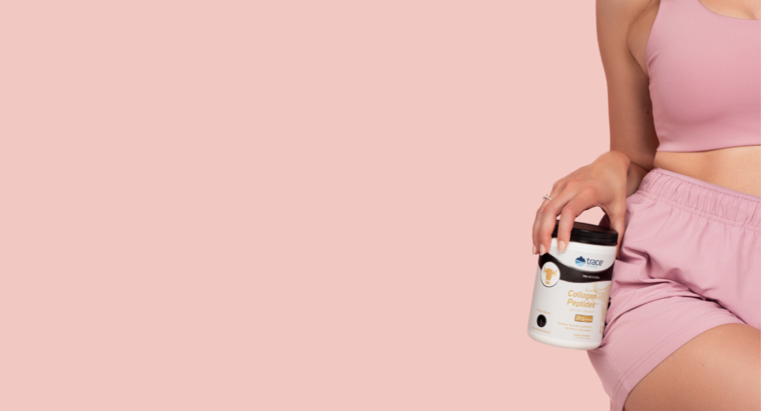 Moteris laiko kolageno peptidų pakuotę rausvame fone. Desktop versijos formatas.