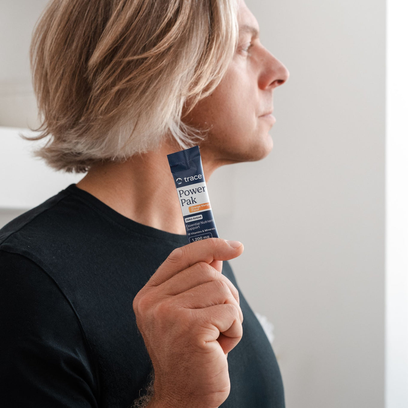 Vyras laiko power pak maisto papildo pakelį rankoje.